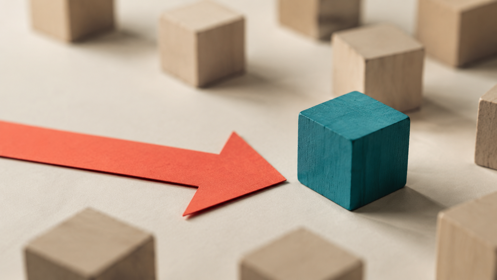 A coral paper arrow points toward one teal block among neutral wooden blocks