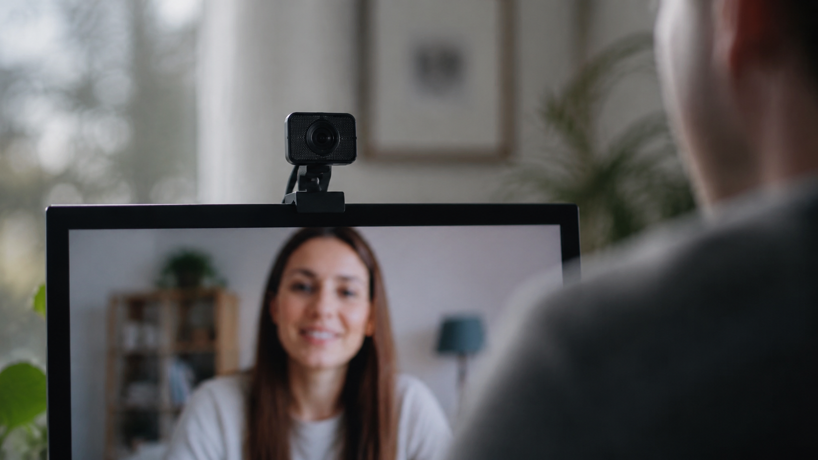 Webcam positioned above a screen showing a remote conversation partner