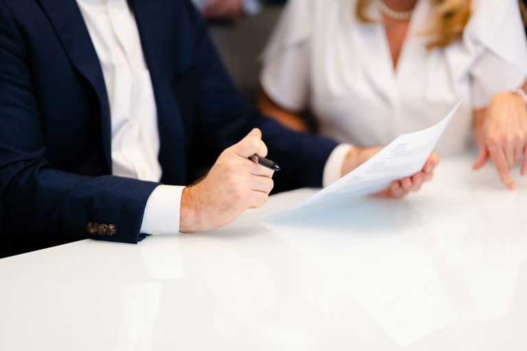 Two people reviewing printed presentation material at a table
